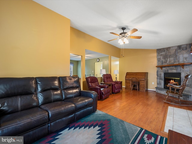 living area featuring wood finished floors, a fireplace, and a ceiling fan