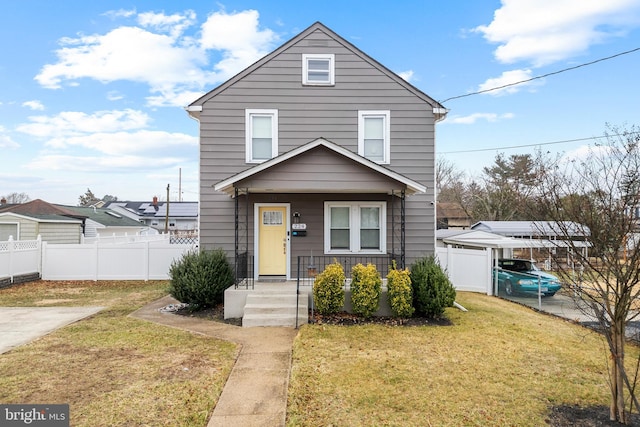 view of front facade featuring a detached carport, a front yard, a porch, and fence