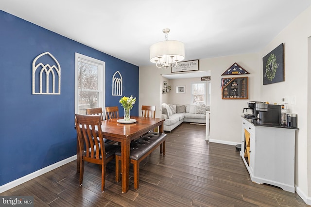 dining room with dark wood-type flooring, baseboards, and a chandelier