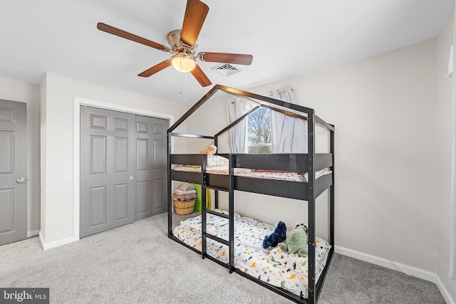 carpeted bedroom with visible vents, baseboards, a closet, and ceiling fan