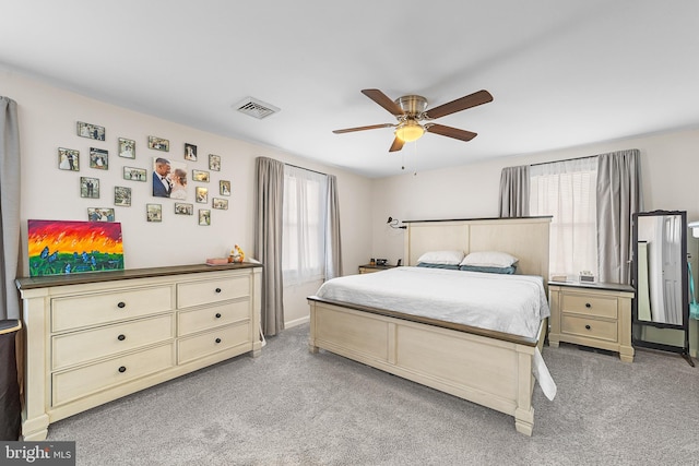 bedroom featuring visible vents, light colored carpet, and a ceiling fan