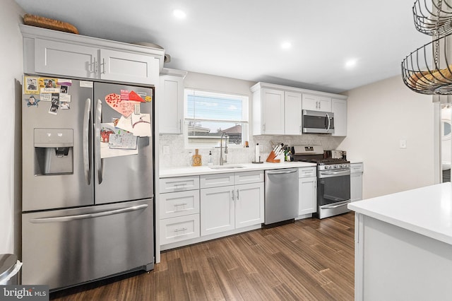 kitchen with dark wood-style floors, stainless steel appliances, light countertops, and a sink