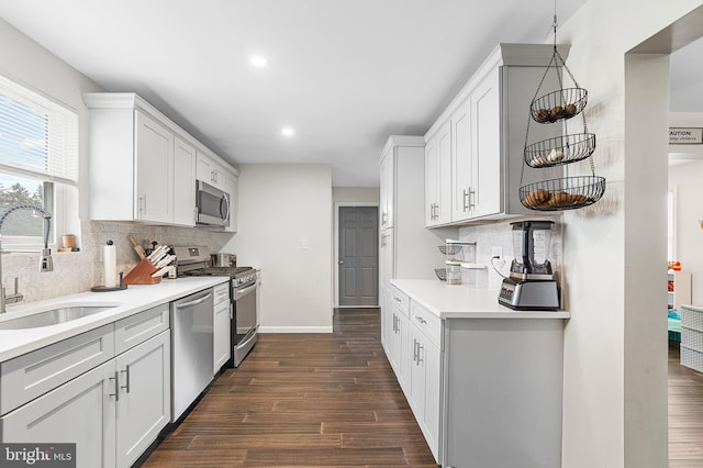 kitchen featuring light countertops, dark wood-style floors, appliances with stainless steel finishes, and a sink