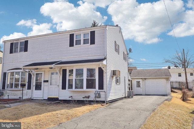view of front facade with driveway, an outbuilding, central air condition unit, and a garage
