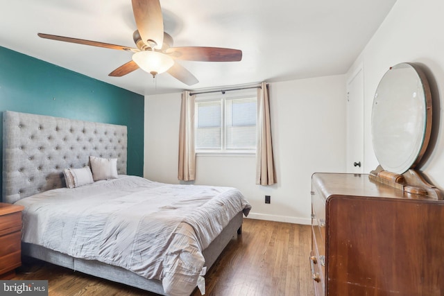 bedroom featuring baseboards, wood finished floors, and ceiling fan