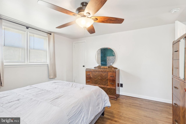 bedroom with baseboards, wood finished floors, and a ceiling fan