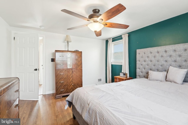 bedroom with a ceiling fan and wood finished floors