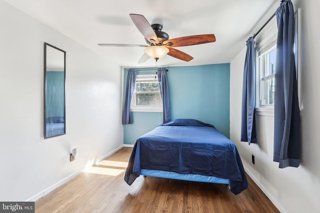 bedroom with baseboards, wood finished floors, and a ceiling fan