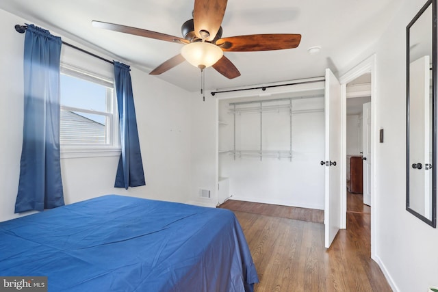 bedroom featuring visible vents, a closet, wood finished floors, and a ceiling fan