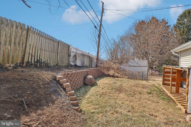 view of yard with a fenced backyard and an outbuilding
