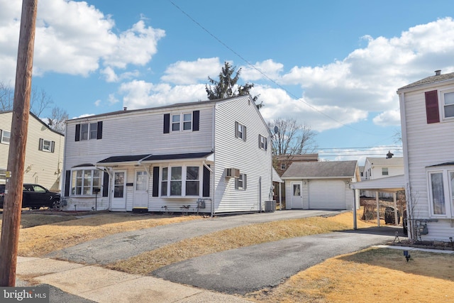 view of front of house featuring driveway, an outdoor structure, and central AC