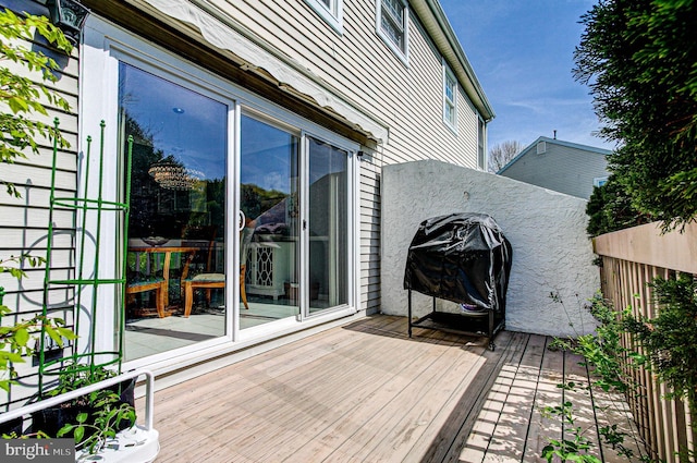wooden terrace with fence and grilling area