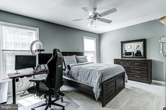 bedroom with light colored carpet, a ceiling fan, and baseboards