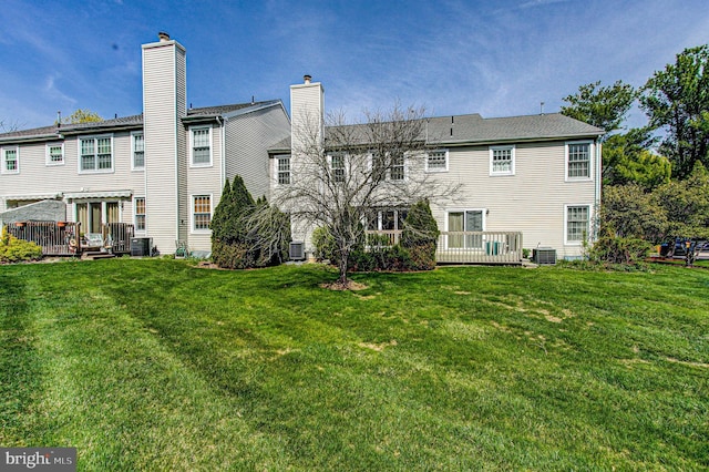 back of property featuring a chimney, central air condition unit, a yard, and a deck