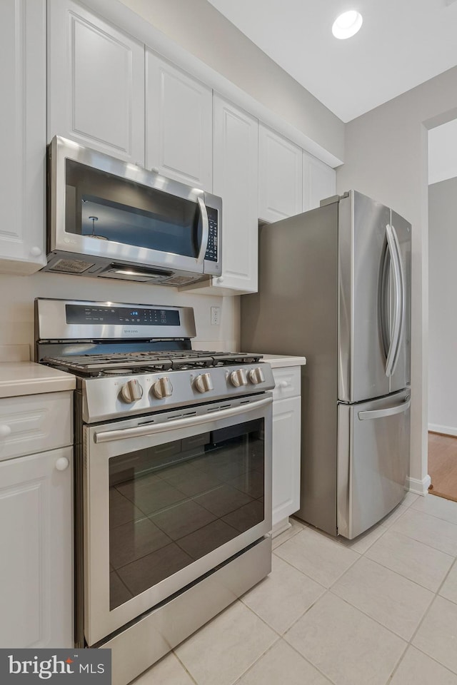 1860 Stratford Park Pl Unit 306, Reston, VA 20190 - kitchen featuring light tile patterned flooring, white cabinetry, light countertops, and appliances with stainless steel finishes