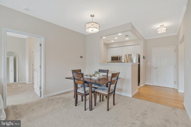 1860 Stratford Park Pl Unit 306, Reston, VA 20190 - dining space featuring crown molding, light carpet, baseboards, and arched walkways