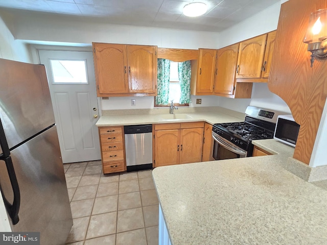 kitchen with light tile patterned floors, brown cabinetry, a sink, stainless steel appliances, and light countertops