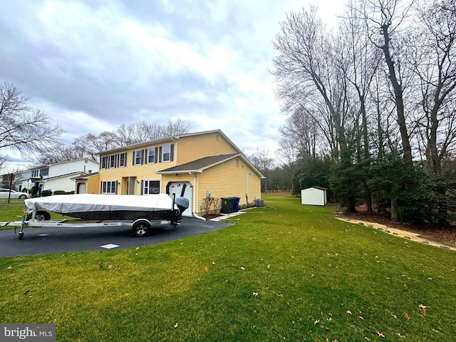 view of side of home with an outbuilding, a shed, a lawn, and a garage