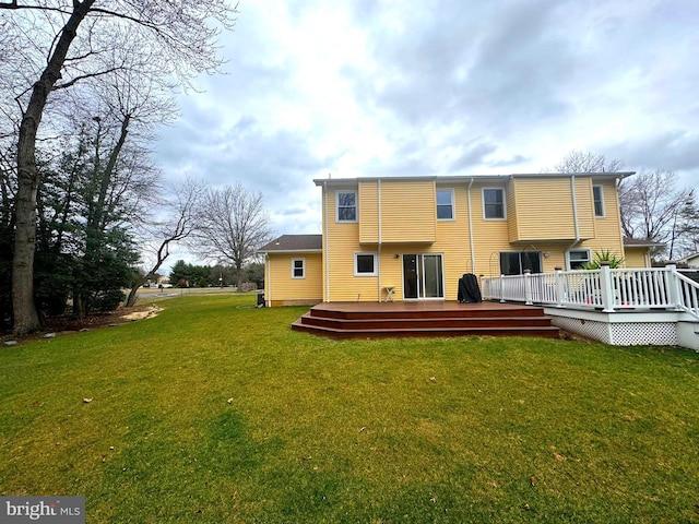 rear view of house with a yard and a wooden deck