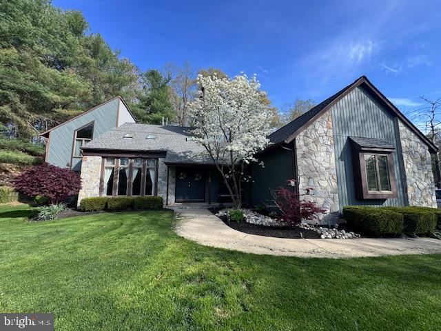 view of front of home featuring a front lawn and stone siding