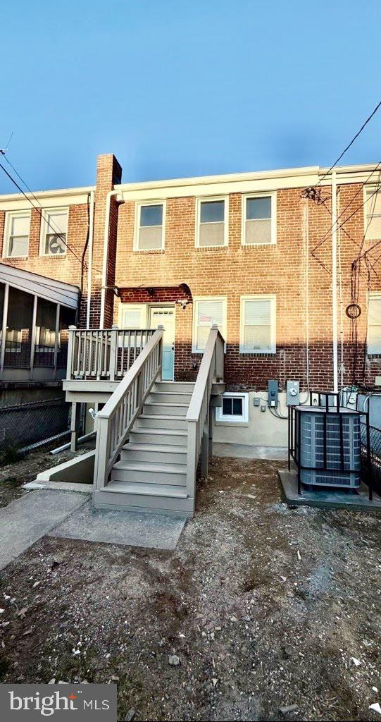 back of property featuring central air condition unit and brick siding