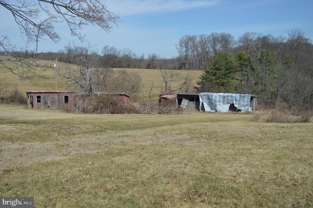 view of yard featuring a rural view and an outdoor structure