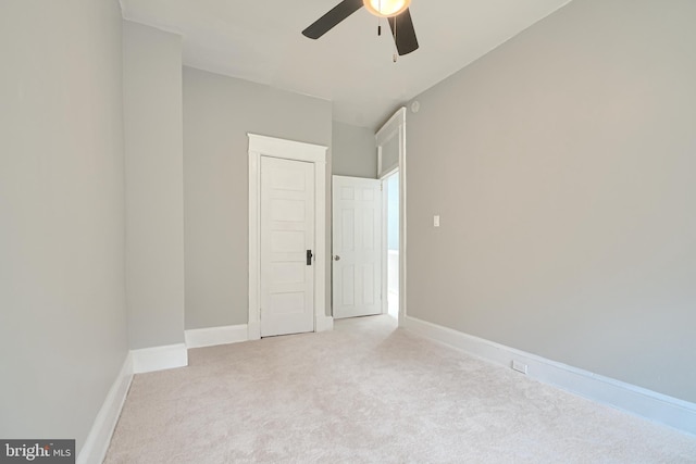 carpeted spare room with baseboards and a ceiling fan