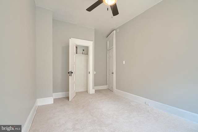 unfurnished bedroom featuring a ceiling fan, light colored carpet, and baseboards