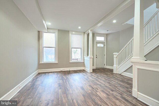 entryway featuring stairway, baseboards, wood finished floors, and ornate columns