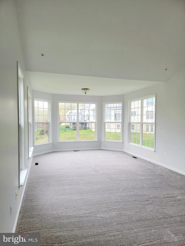 empty room featuring carpet flooring, baseboards, and visible vents