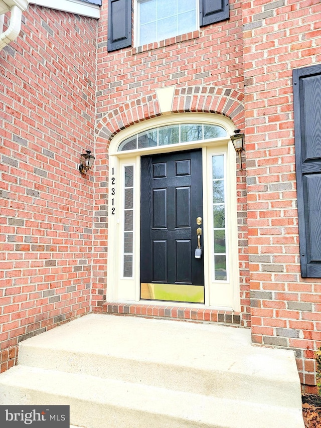 view of exterior entry featuring brick siding