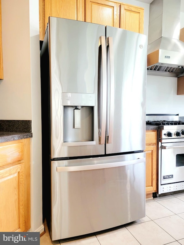 kitchen with appliances with stainless steel finishes, light tile patterned floors, light brown cabinets, island exhaust hood, and dark countertops