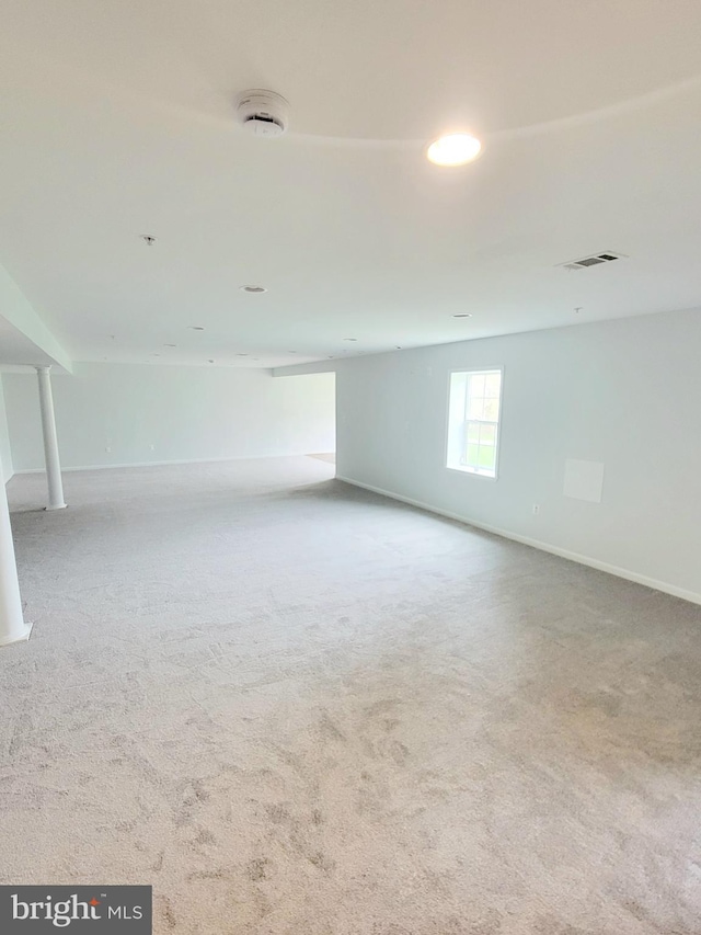 basement featuring baseboards, visible vents, and carpet