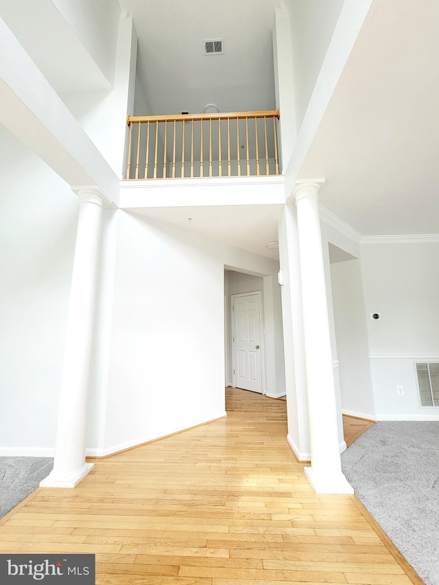 interior space featuring ornate columns, visible vents, and wood finished floors