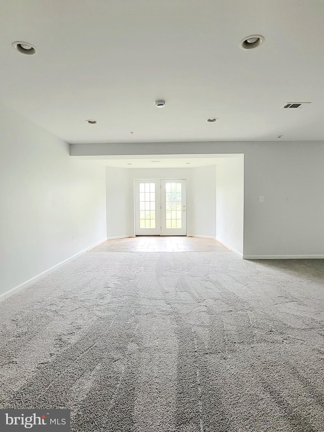 carpeted spare room with baseboards and visible vents