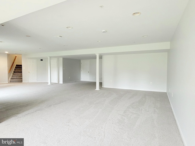 finished basement featuring light carpet, stairs, baseboards, and recessed lighting