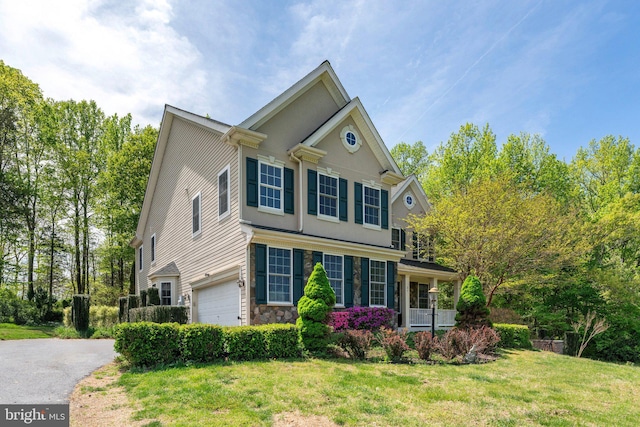 view of home's exterior featuring a lawn, stone siding, an attached garage, and aphalt driveway
