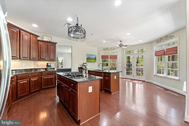 kitchen featuring a center island, visible vents, appliances with stainless steel finishes, and dark wood finished floors