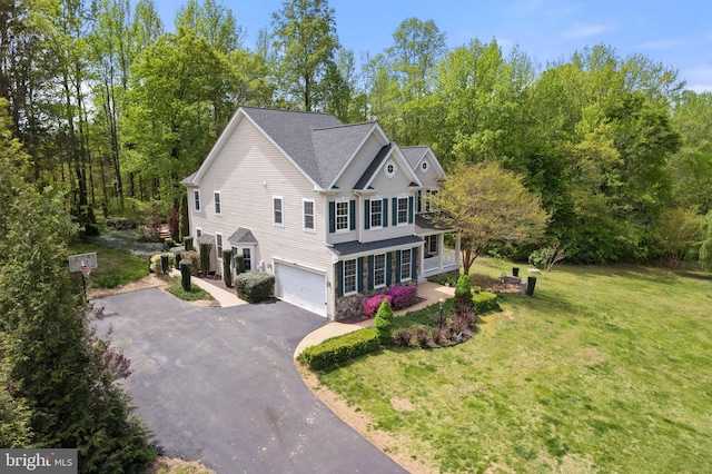 view of side of property with a garage, roof with shingles, driveway, and a lawn