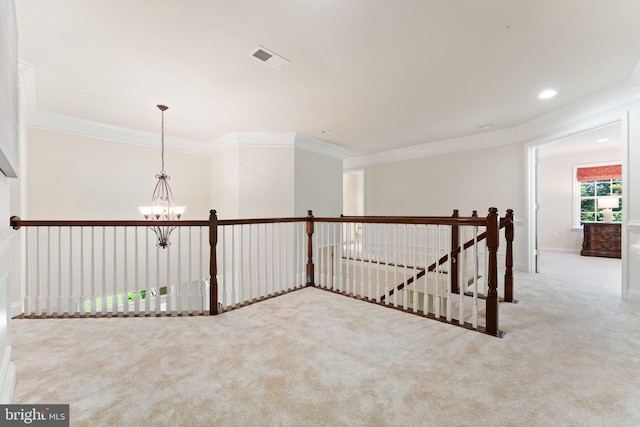 hallway with an upstairs landing, ornamental molding, a notable chandelier, and carpet flooring