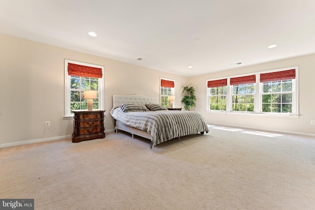 bedroom featuring carpet, visible vents, baseboards, and multiple windows