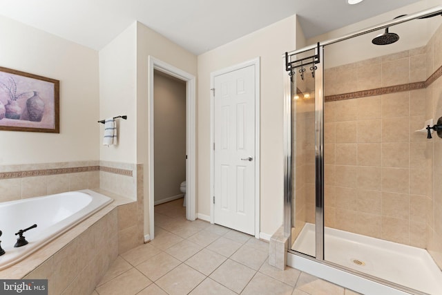 full bathroom featuring toilet, a shower stall, a bath, and tile patterned flooring