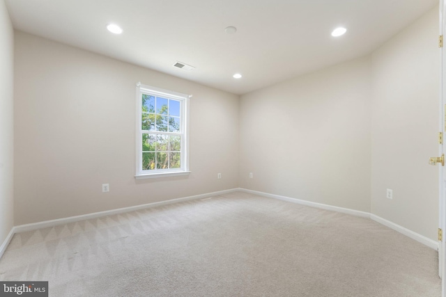 empty room featuring visible vents, baseboards, recessed lighting, and light carpet
