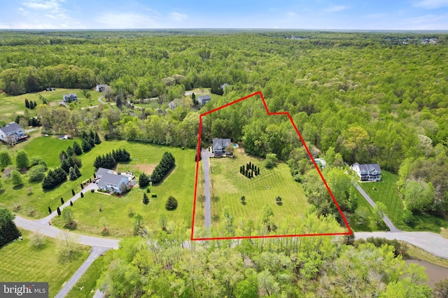 birds eye view of property featuring a forest view
