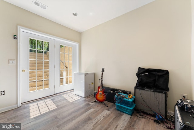 entryway with wood finished floors, visible vents, and baseboards