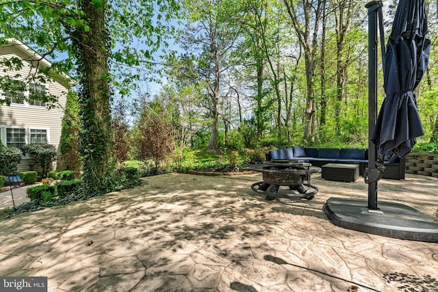 view of community featuring an outdoor living space with a fire pit and a patio area