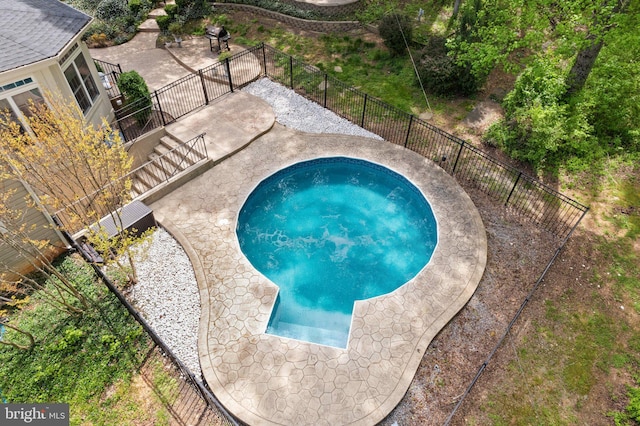 view of pool with fence, a patio area, and a jacuzzi