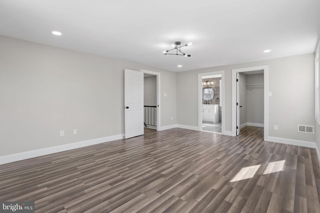 unfurnished living room with dark wood finished floors, visible vents, recessed lighting, and baseboards