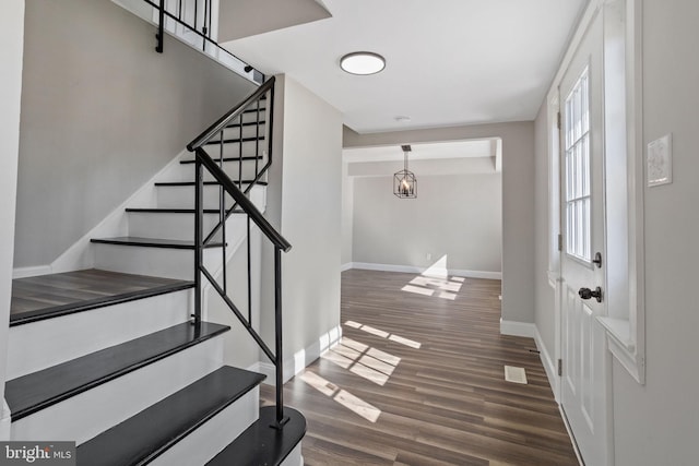 foyer entrance featuring stairs, wood finished floors, and baseboards
