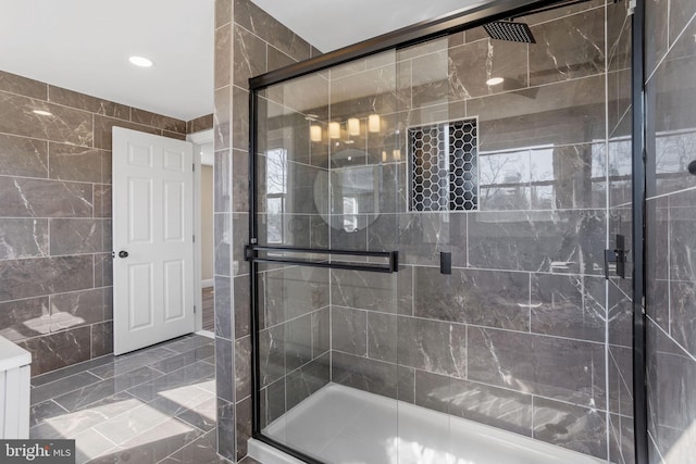 bathroom with a shower stall and tile walls